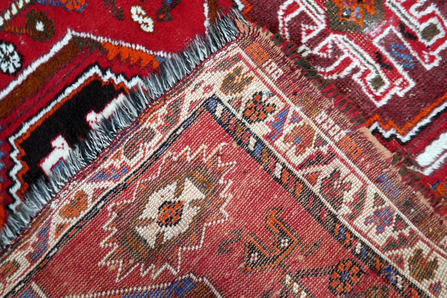Vintage Shiraz wool rug texture detail, dense pile with natural sheen