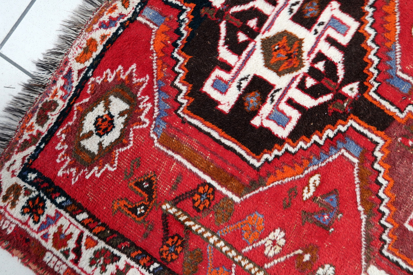 Handmade Shiraz rug detail, bold red and blue tribal motifs