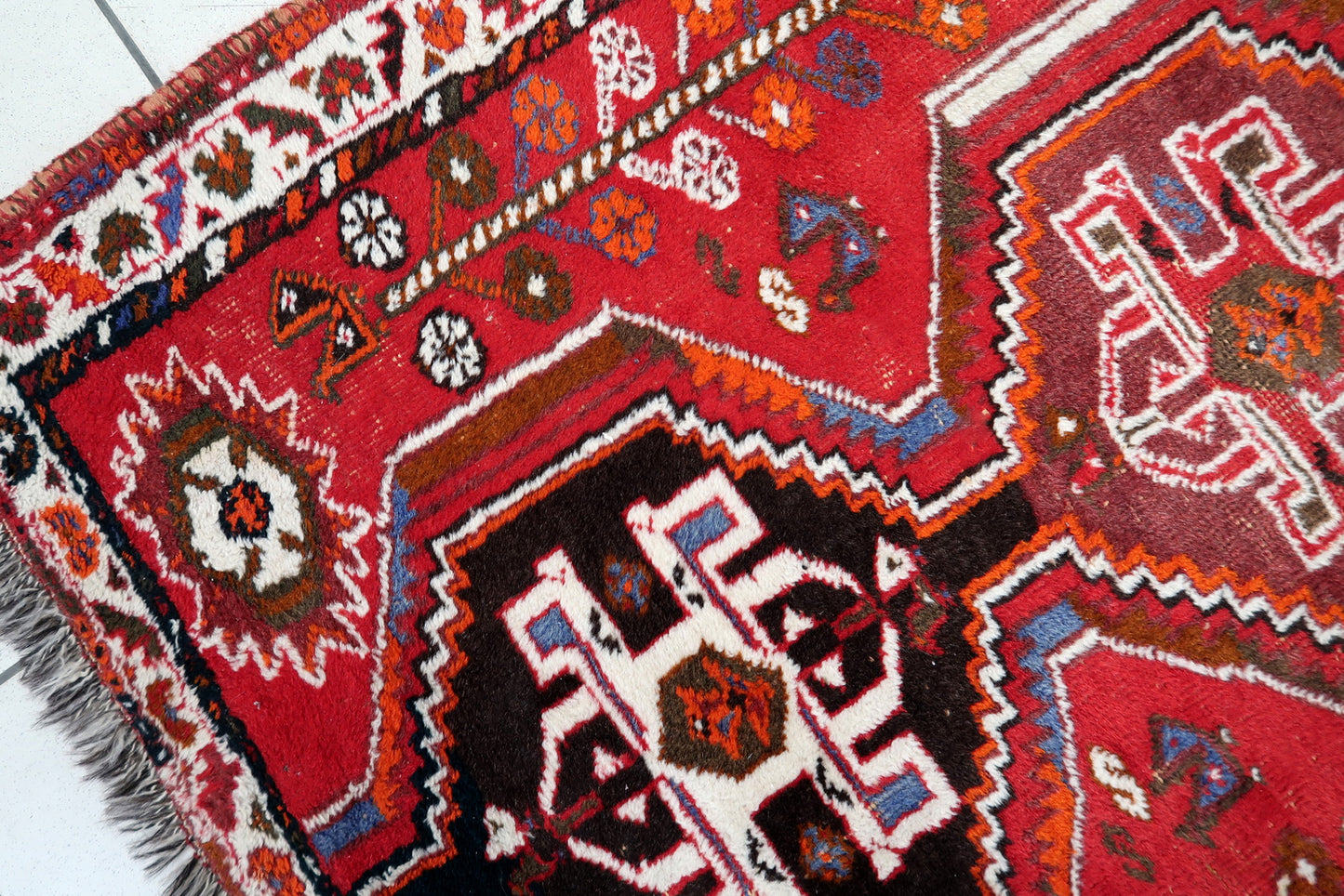 Shiraz rug corner detail, showcasing craftsmanship and aged patina