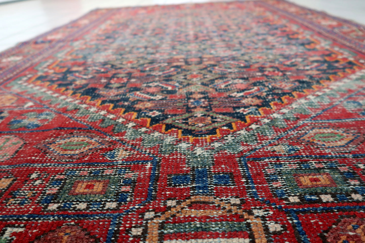 Handmade antique wool rug from Persia's Hamadan region, showcasing a classic Herati-inspired pattern and a highly desirable distressed patina.

