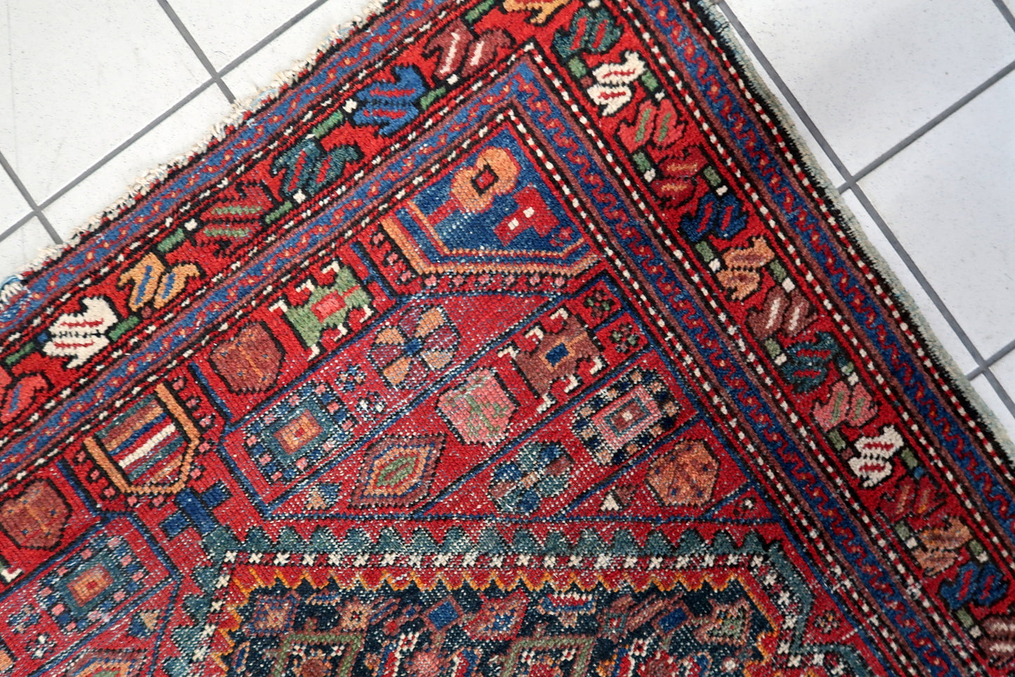 Antique distressed Persian Hamadan rug circa 1920s, hand-knotted wool on cotton foundation, displaying rich red and navy color palette with softened tribal details.

