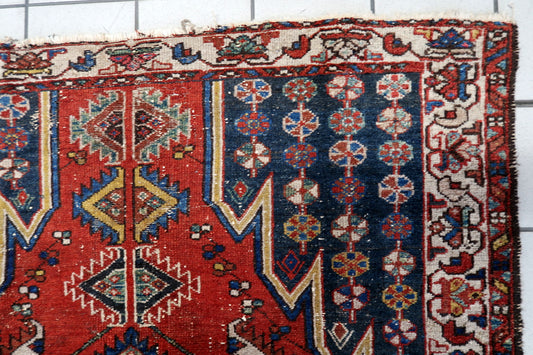 Vintage 1920s Persian Hamadan rug in red and navy blue, showcasing a tribal geometric design, intricate ivory border, and worn, low-pile texture suitable for eclectic interiors.