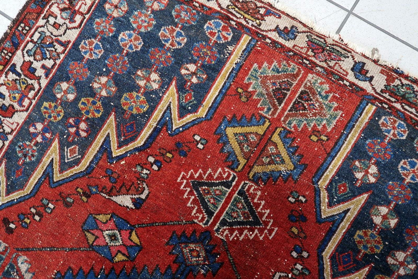 Distressed antique Persian Hamadan rug, hand-knotted wool on a cotton foundation, with a bold medallion and decorative motifs, measuring 4.2 feet wide by 6.4 feet long.

