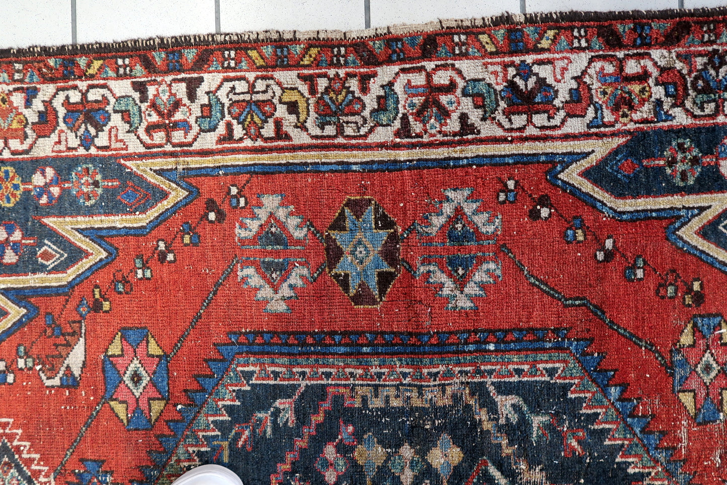 Handmade 1920s Hamadan rug in a distressed condition, ideal for adding character to an entryway or bedroom with its bold geometric and tribal design elements.

