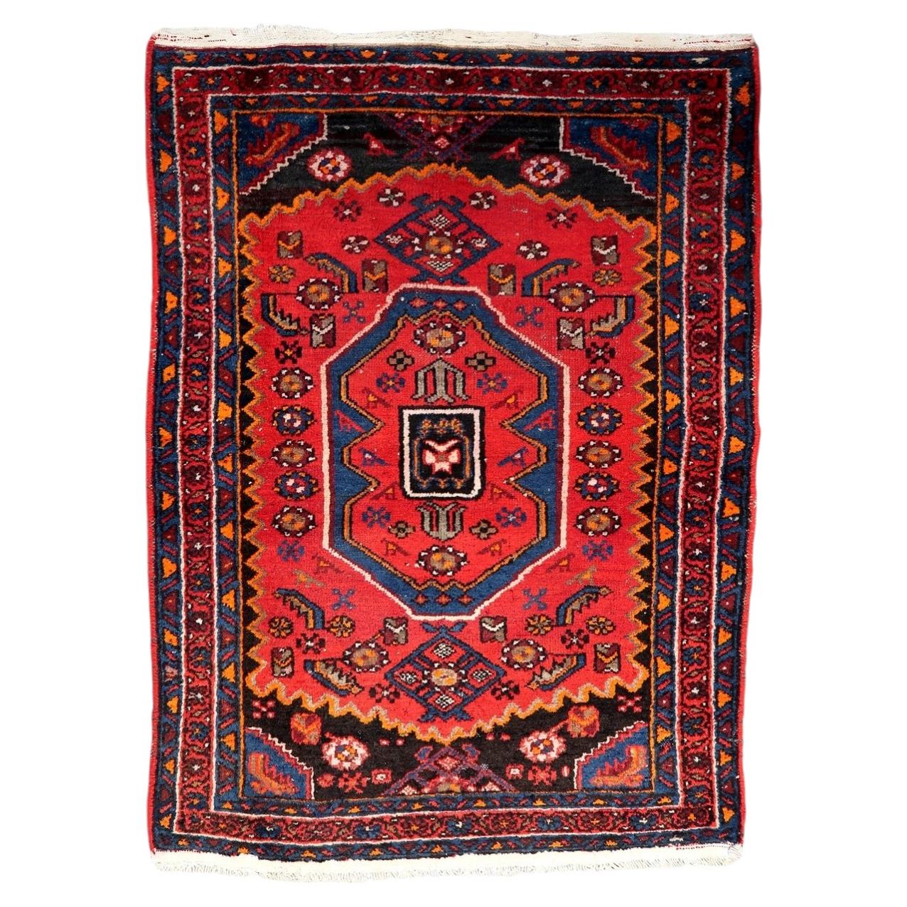 Handmade vintage Persian Hamadan rug from the 1930s in good condition, featuring a vibrant red field with a stylized geometric medallion on a 3.4 by 4.7 foot wool carpet.

