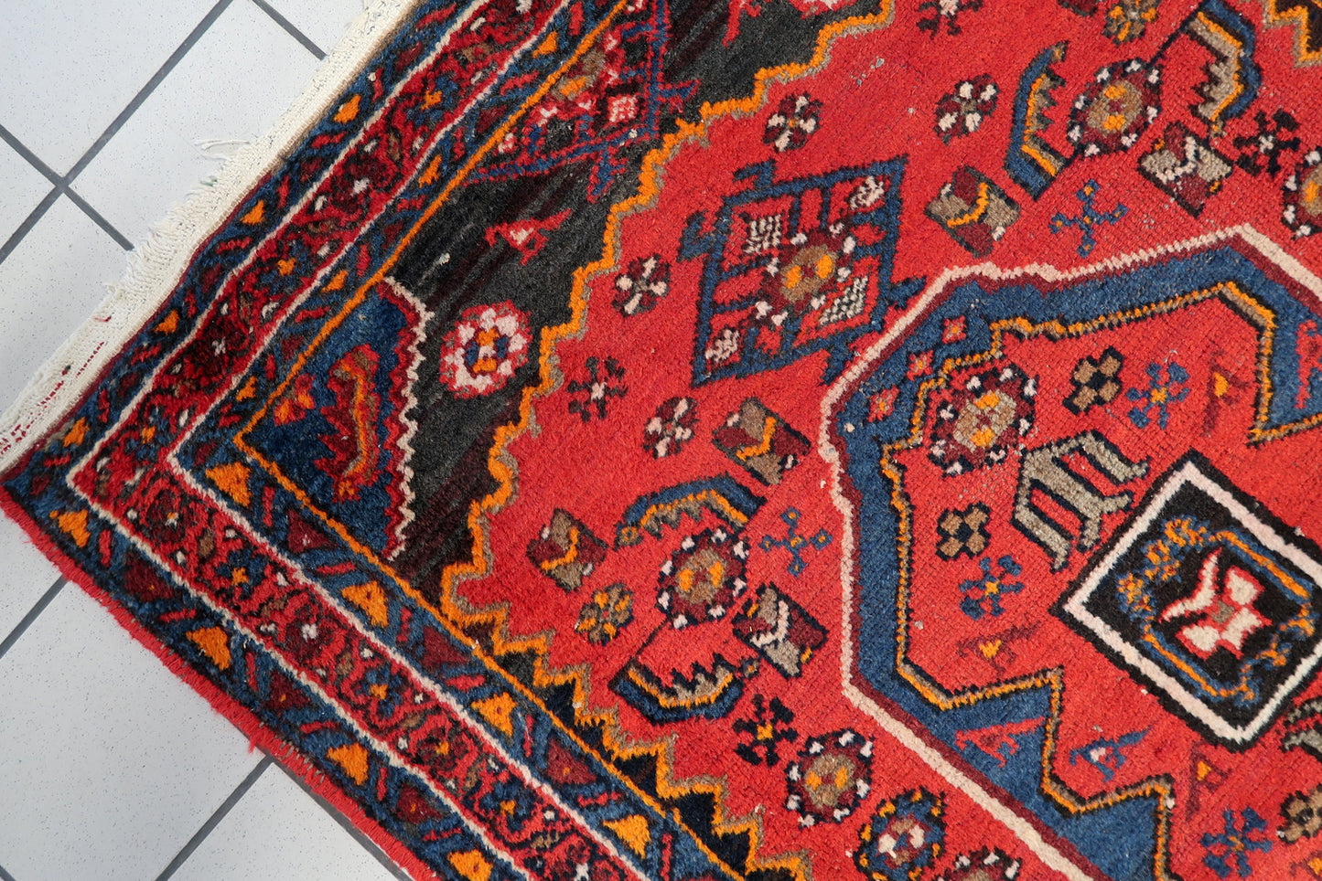 Authentic 1930s Persian Hamadan rug in good vintage condition, combining a bold red field, traditional tribal motifs, and a soft wool texture for timeless appeal.


