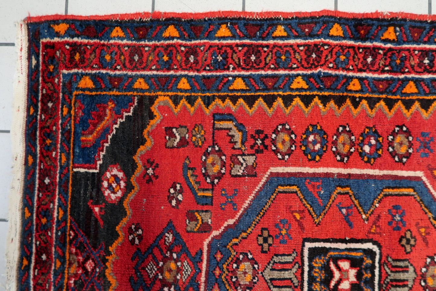 Handmade 1930s Hamadan rug with a balanced symmetrical composition, featuring warm orange and soft blue details against a deep navy and ivory border.

