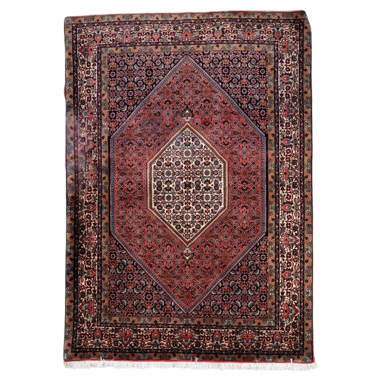 Vintage handmade Persian Bidjar rug from the 1950s, known as an "iron rug" for its dense, durable weave, featuring a central medallion on a deep red field, sized 6.9 by 4.4 feet.

