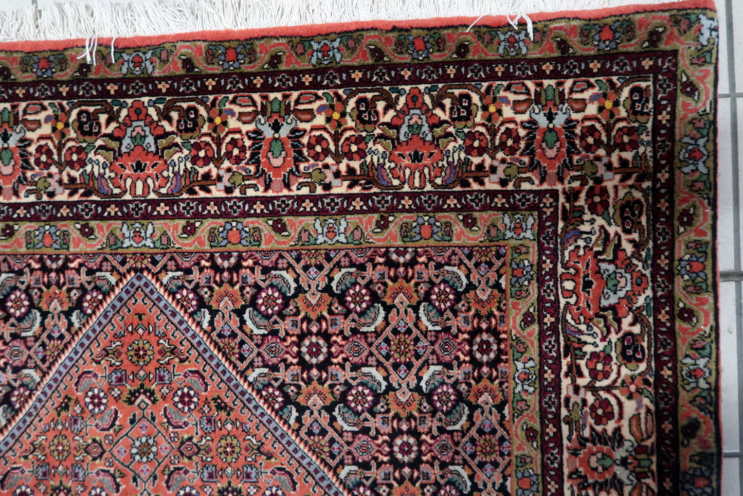 Handmade 1950s Persian Bidjar carpet in good overall condition, showcasing a classic central medallion design with intricate geometric and floral motifs in navy, ivory, and multicolored accents.

