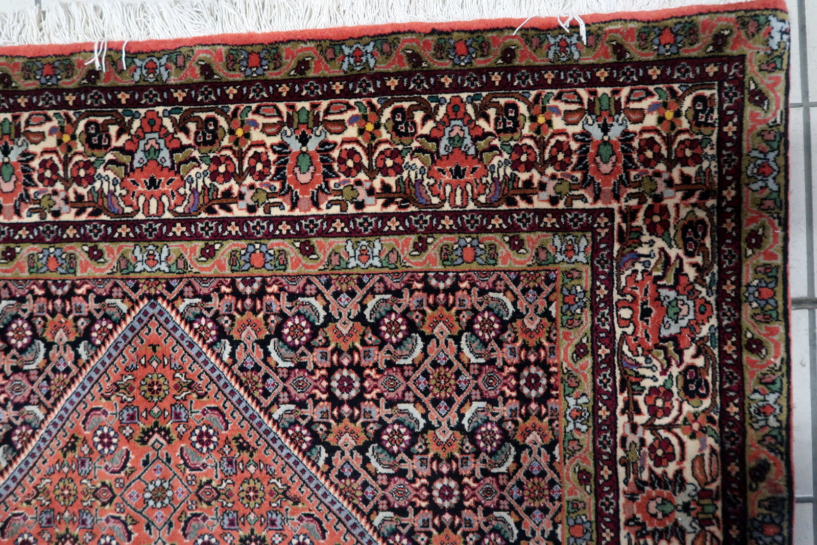 Handmade 1950s Persian Bidjar carpet in good overall condition, showcasing a classic central medallion design with intricate geometric and floral motifs in navy, ivory, and multicolored accents.

