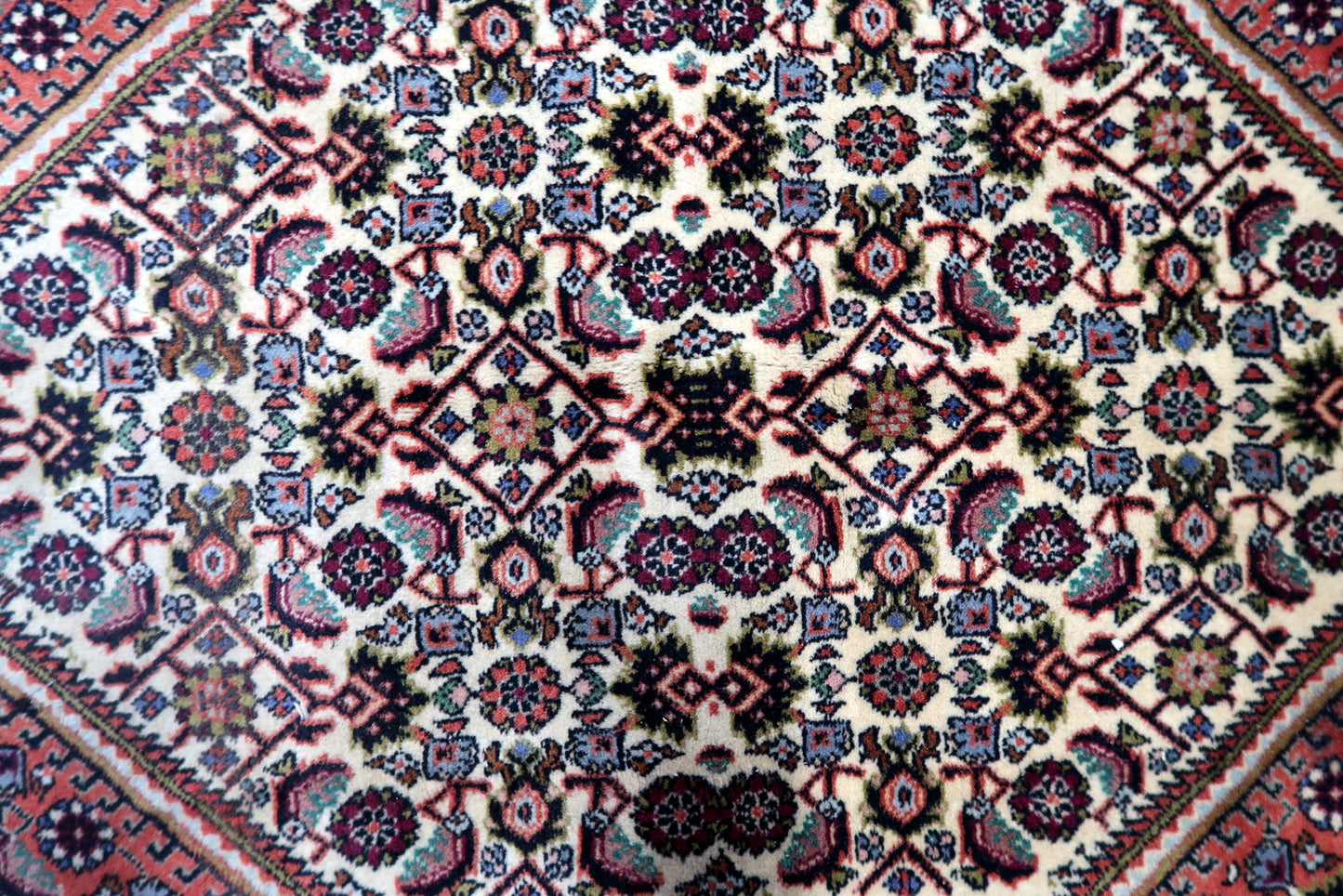 Handmade Bidjar rug from the 1950s with a strong, compact weave, featuring a classic medallion surrounded by repeating geometric motifs and an ivory border.

