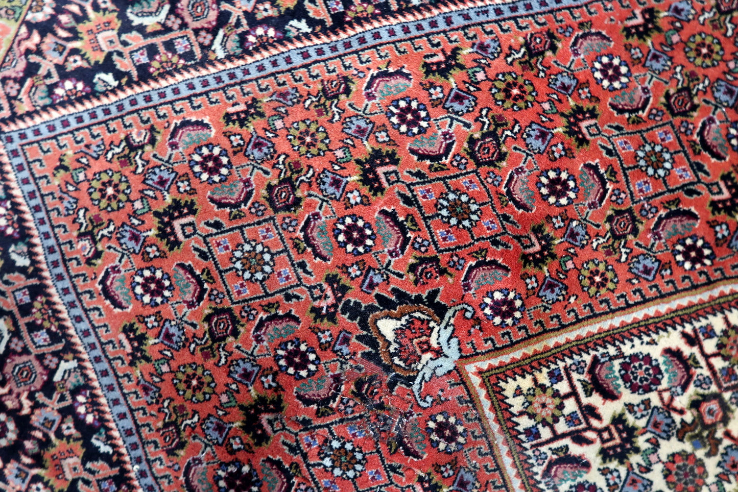 Vintage wool rug from Persia's Bidjar region, showcasing exceptional density, minor signs of wear consistent with age, and a beautifully preserved decorative appeal.

