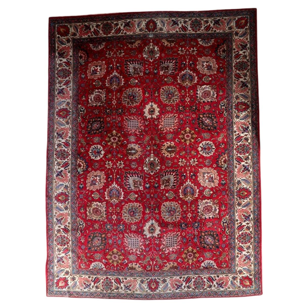 Full view of an antique Persian Tabriz rug from the 1920s, featuring an allover Shah Abbasi floral scroll on a deep crimson lacquer red field with large palmettes in ivory, pink, teal, and navy, plus lotus blossoms, cloud bands, sickle leaves, and flowering branches – a full room-size rug measuring 9.11 × 13.2 feet.

