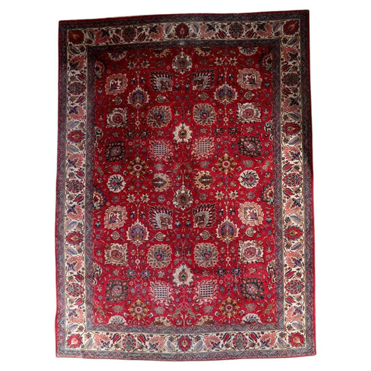 Full view of an antique Persian Tabriz rug from the 1920s, featuring an allover Shah Abbasi floral scroll on a deep crimson lacquer red field with large palmettes in ivory, pink, teal, and navy, plus lotus blossoms, cloud bands, sickle leaves, and flowering branches – a full room-size rug measuring 9.11 × 13.2 feet.

