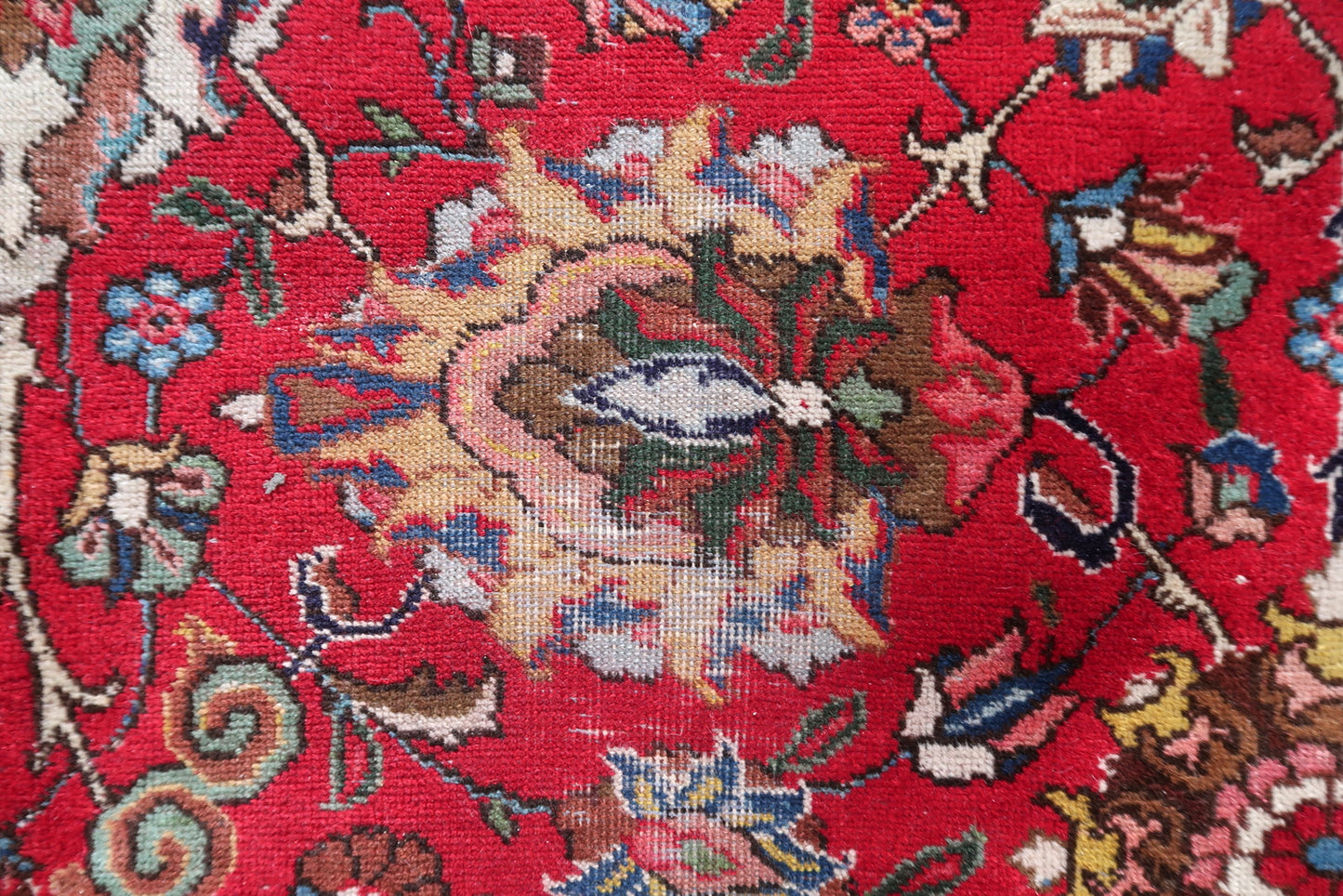 Full view of an antique Persian allover floral Tabriz rug laid flat, showing its rectangular shape, wide ivory border, teal guard borders, and the continuous interlocking floral scroll covering the entire crimson field with no empty ground visible.

