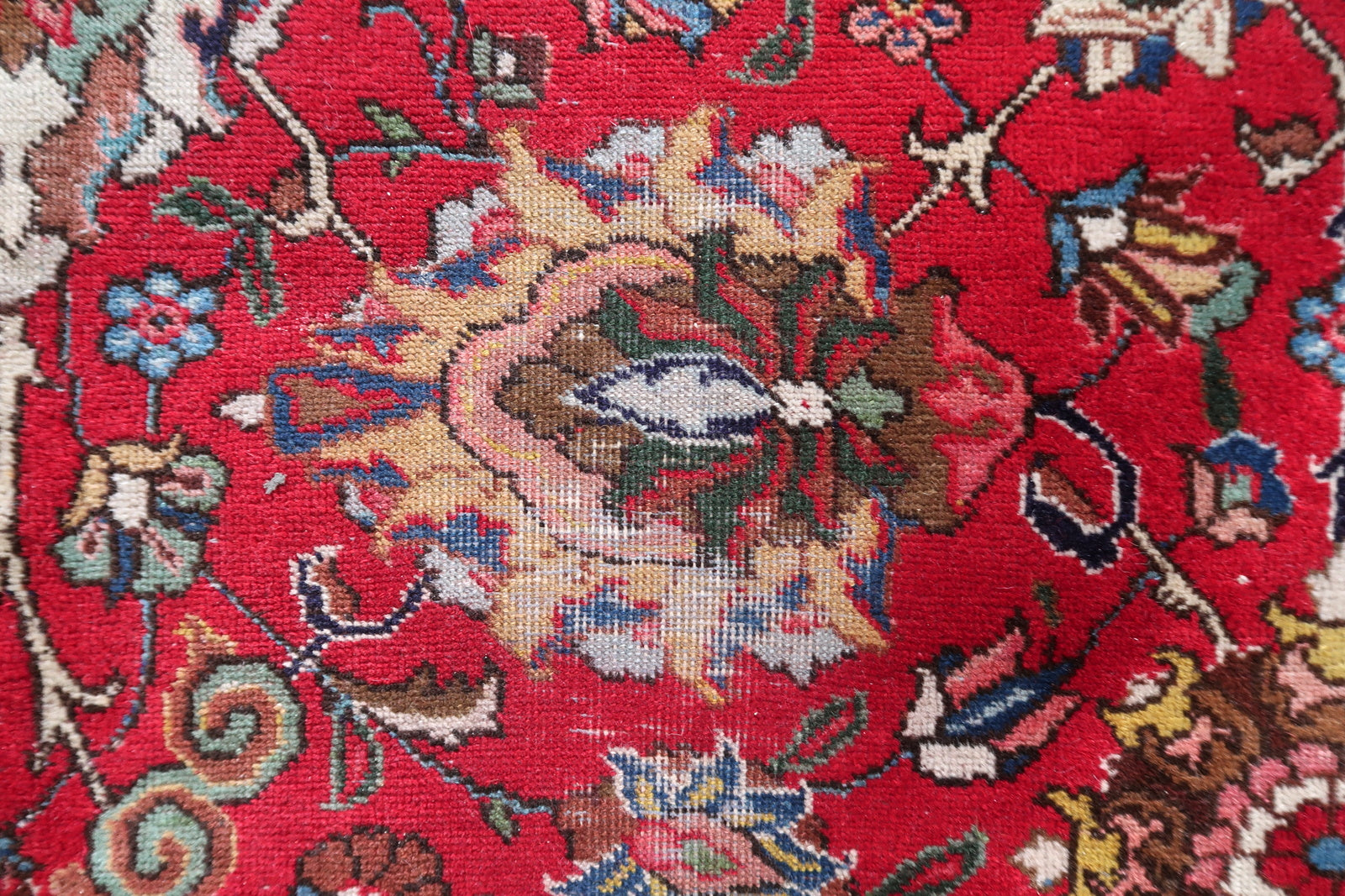 Full view of an antique Persian allover floral Tabriz rug laid flat, showing its rectangular shape, wide ivory border, teal guard borders, and the continuous interlocking floral scroll covering the entire crimson field with no empty ground visible.

