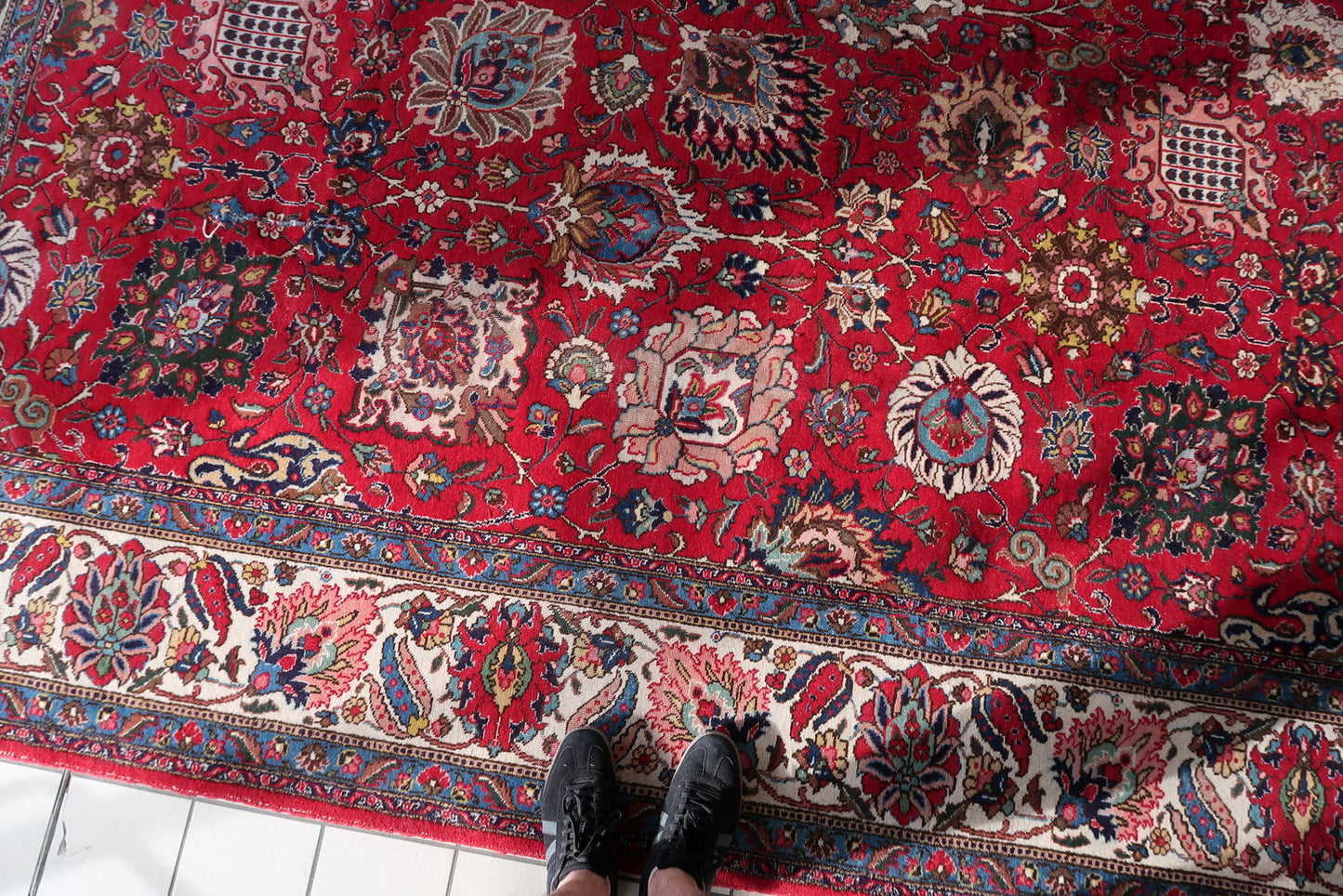 Detail of the pink vase or ewer motif with dotted grid body on a 1920s Persian Tabriz allover floral rug, a classic Tabriz field element anchoring one section of the composition.

