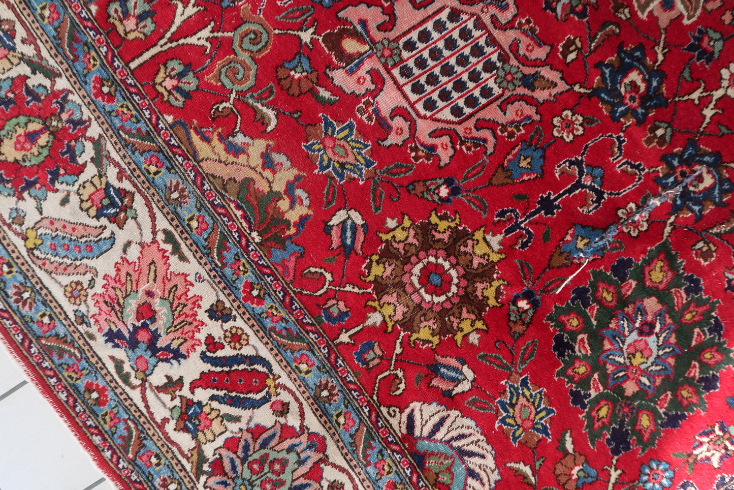 Antique Persian Tabriz rug in room-size format (303 × 403 cm), hand-knotted circa 1920s in the northwestern Middle Eastern workshop tradition, with a wide ivory-ground main border featuring red palmettes, pink acanthus leaves, and blue lotus flowers.

