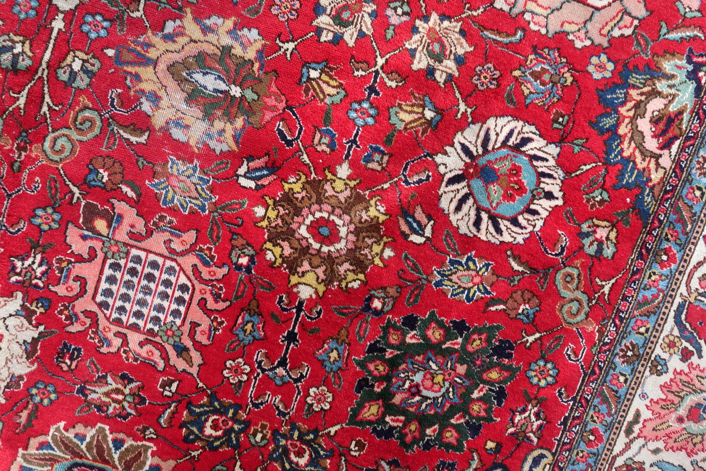 Antique hand-knotted wool rug from Tabriz, circa 1920s, in good antique condition with uneven pile (full in some areas, reduced in others) consistent with a century of use, but with vivid saturated colors throughout and fully legible design.

