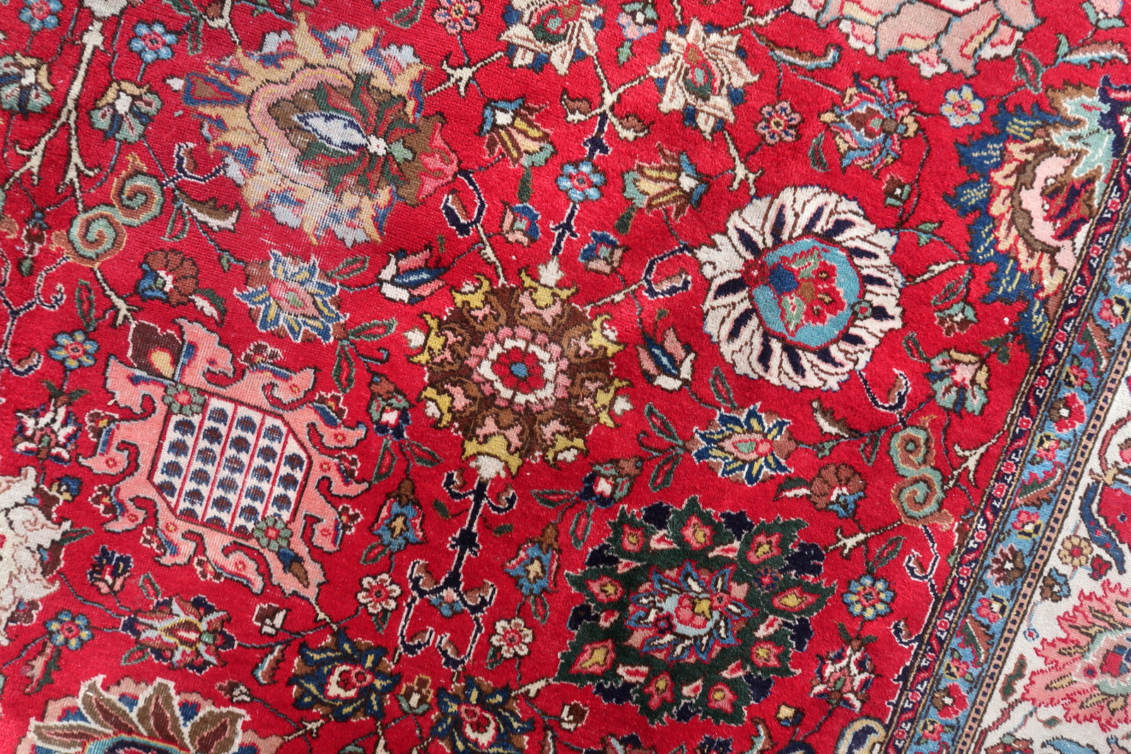 Antique hand-knotted wool rug from Tabriz, circa 1920s, in good antique condition with uneven pile (full in some areas, reduced in others) consistent with a century of use, but with vivid saturated colors throughout and fully legible design.

