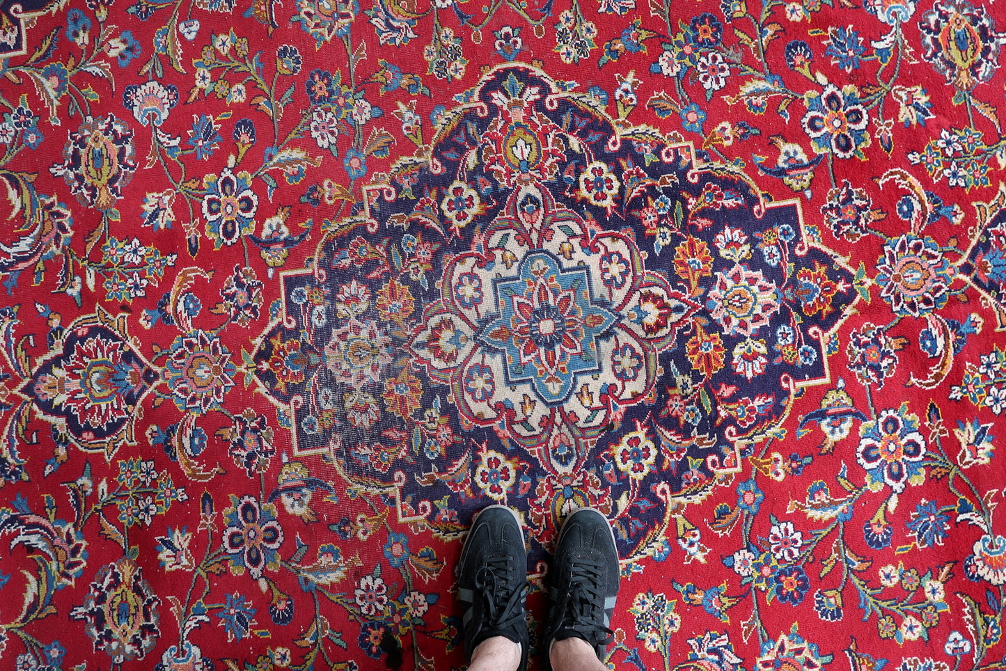 Antique Persian workshop rug from Kashan, hand-knotted circa 1920s with asymmetric (Persian) knots in fine density, featuring the most celebrated format in the Kashan repertoire: central medallion with allover floral field and navy spandrels.

