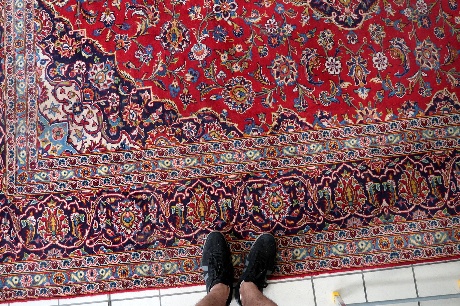 Antique Persian Kashan carpet circa 1920s in good antique condition with honest wear – central medallion area shows most significant pile reduction (some foundation visibility), colors vivid throughout, no major repairs visible, lies flat and presents well.

