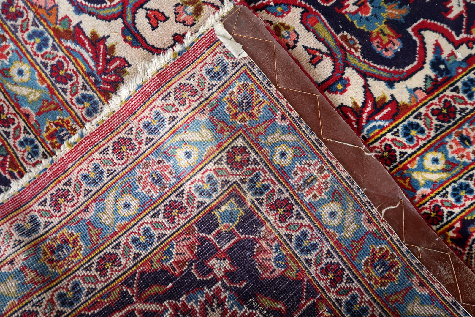 Full view of a circa 1920s Persian Kashan rug with a central medallion pendant surround extending top and bottom, sharply transitioning from navy to the crimson field – the mark of a master Kashan cartoonist at the height of the tradition.

