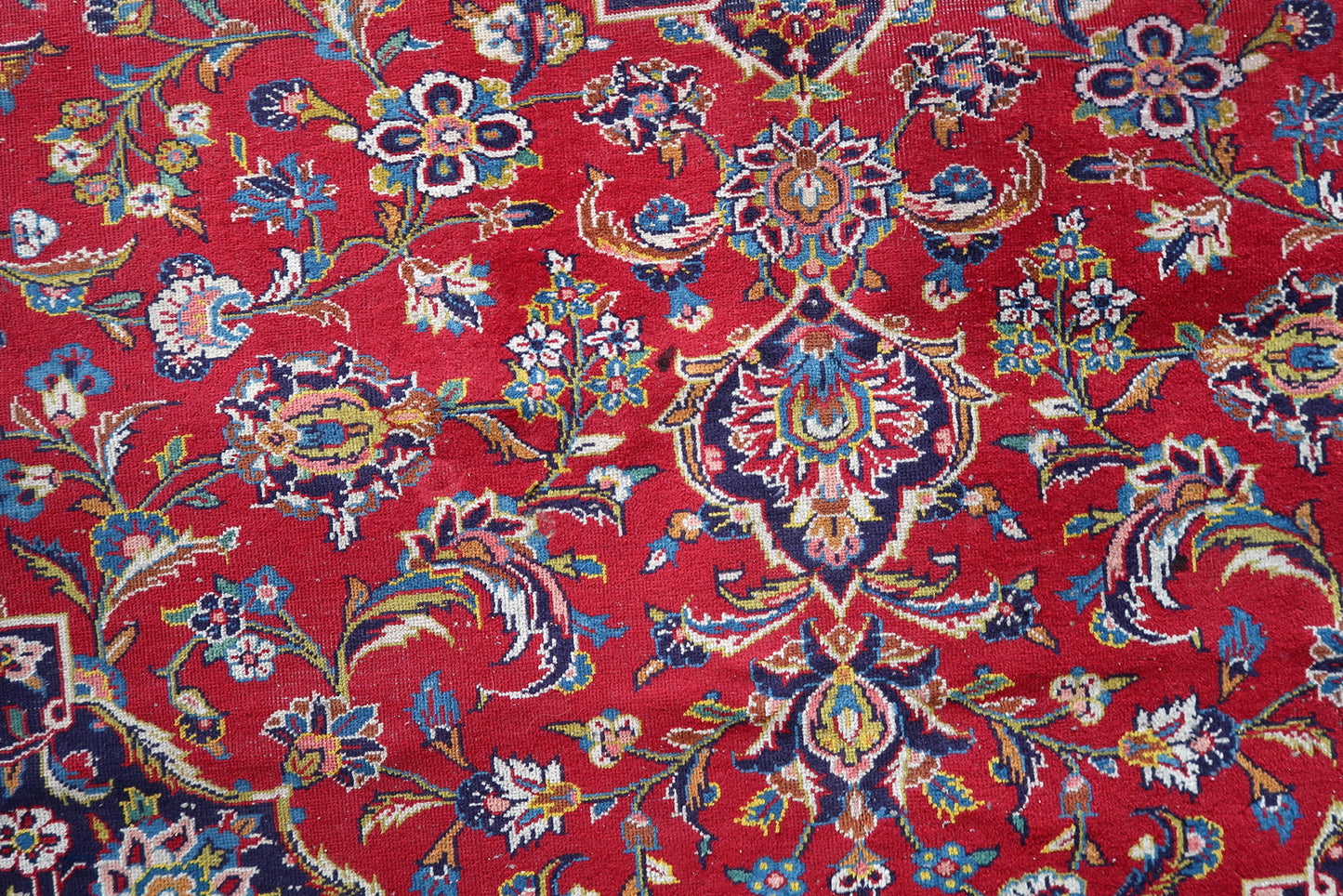 Full perspective of an antique Kashan rug displayed in a formal interior, demonstrating its generous 9'3" × 12'7" size suitable for anchoring a dining room or grand living room.

