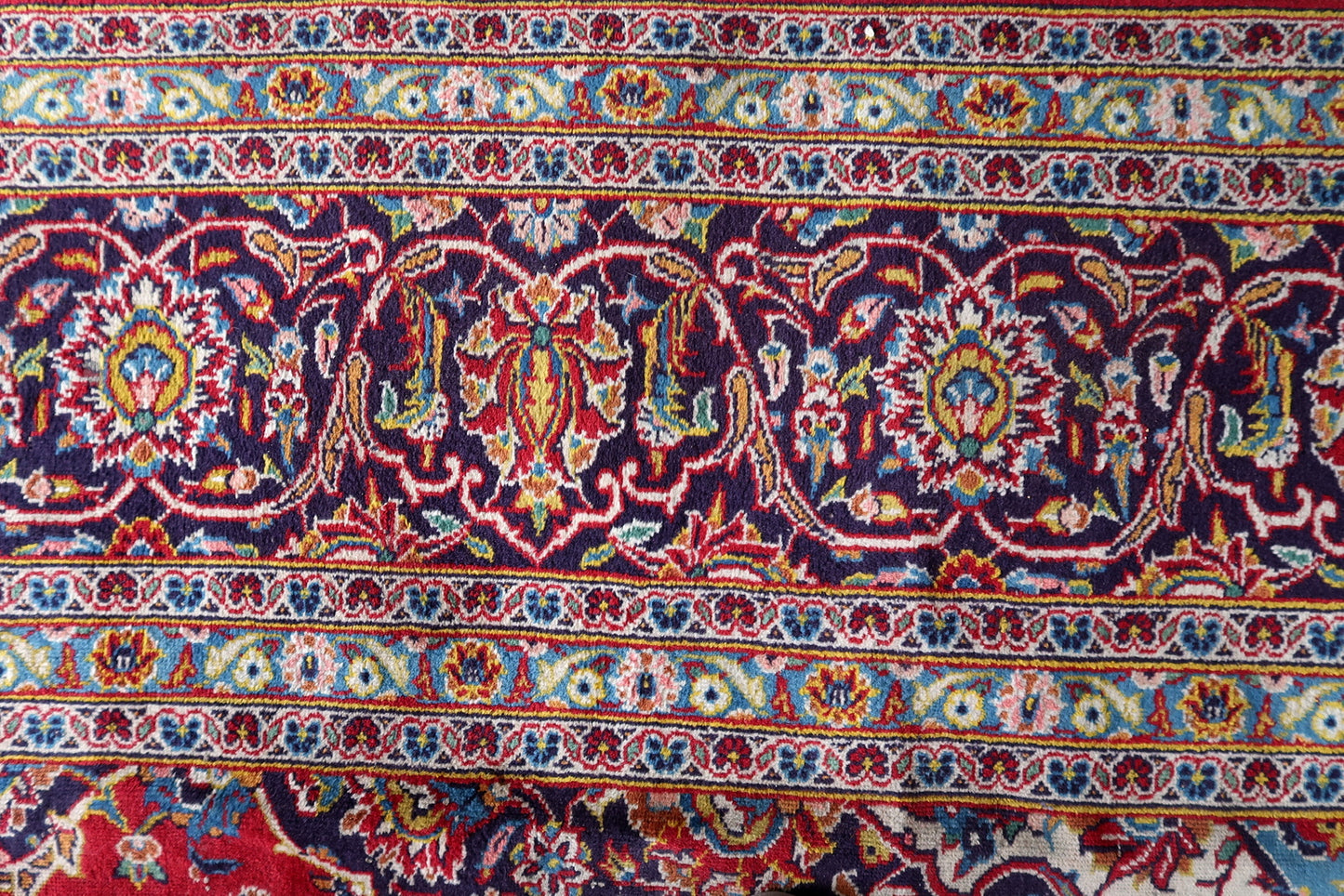 Antique hand-knotted wool rug from Kashan, circa 1920s, in good antique condition with uneven pile – most significant reduction in the central medallion area with some foundation visibility – but with vivid saturated colors and fully legible design throughout.

