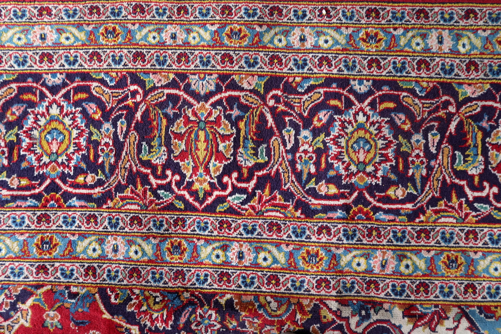 Antique hand-knotted wool rug from Kashan, circa 1920s, in good antique condition with uneven pile – most significant reduction in the central medallion area with some foundation visibility – but with vivid saturated colors and fully legible design throughout.

