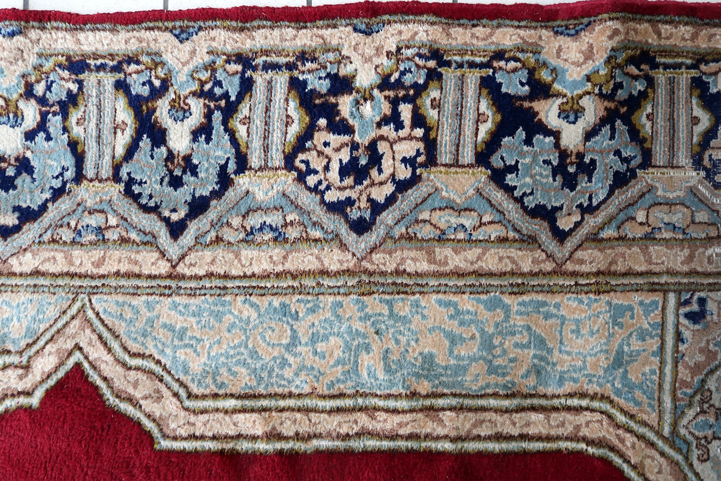 Close-up of the open crimson field on a 1930s Persian Kerman rug, showing the dense, lustrous, even Kork wool pile with the distinctive velvet-like sheen that separates genuine antique Kerman from all imitations.


