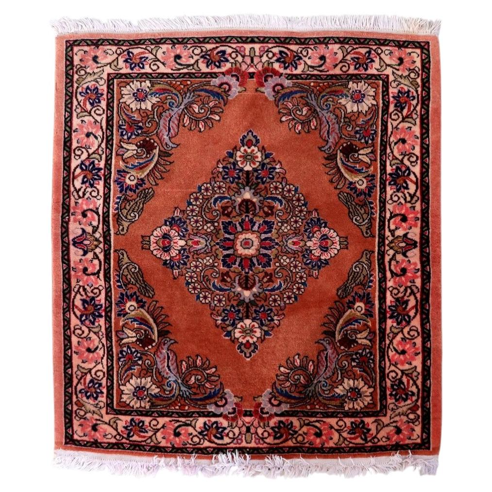 Vintage Persian Sarouk rug with rose‑salmon field and central diamond medallion

