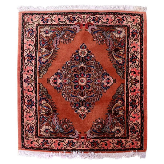 Vintage Persian Sarouk rug with rose‑salmon field and central diamond medallion

