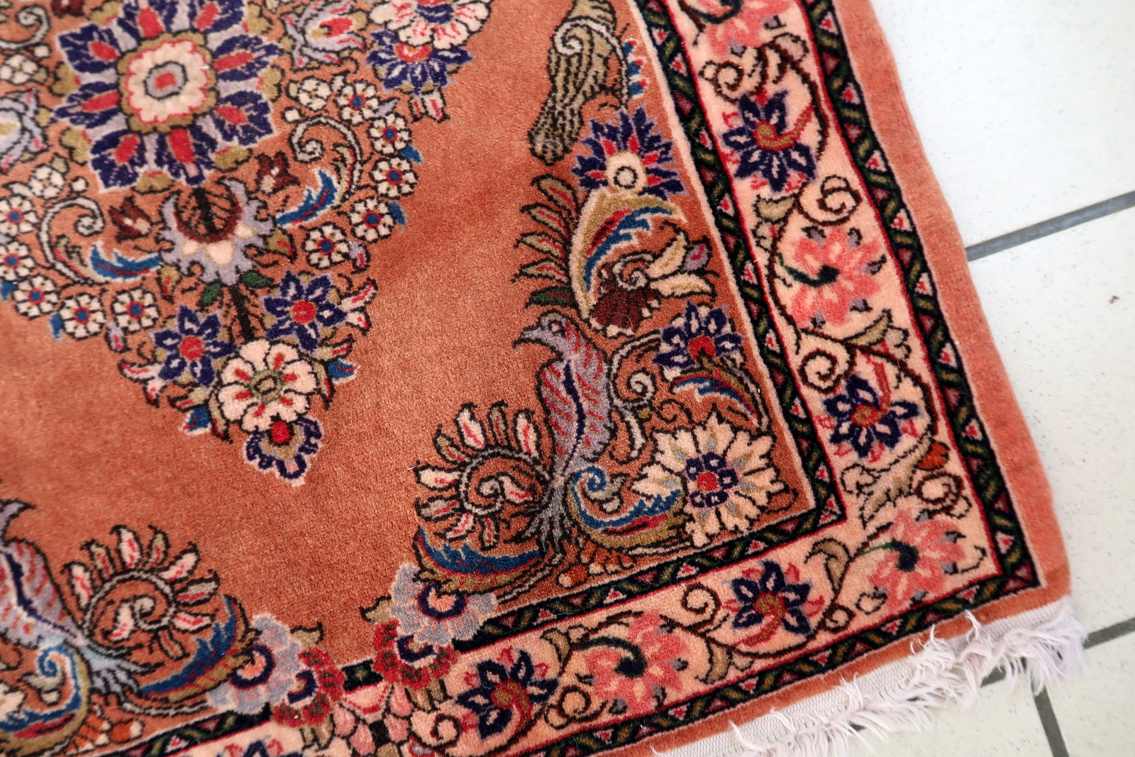 Small Persian Sarouk mat with salmon‑rose field and navy‑outlined diamond medallion

