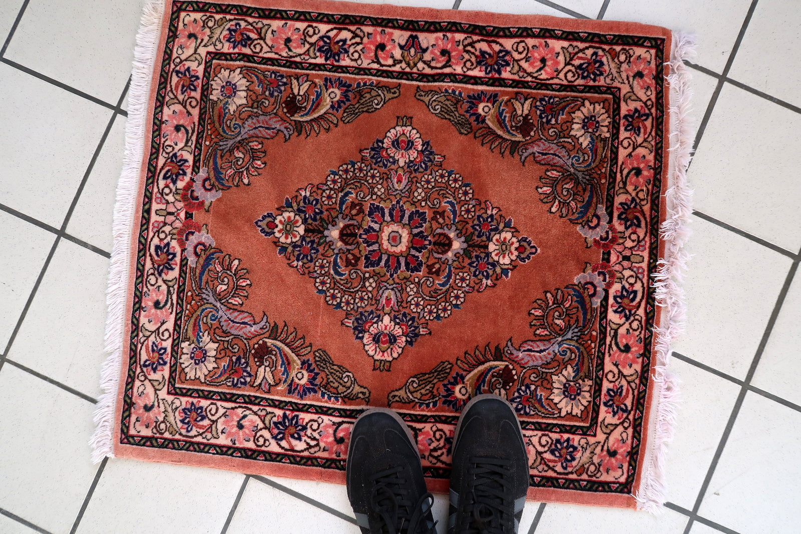 Hand‑knotted Sarouk mat featuring boteh corner sprays and open terracotta field

