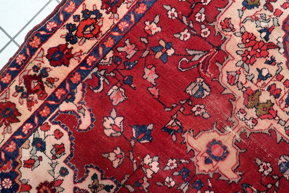 Natural color variations and abrash tonal shading in the hand-dyed wool yarn of an authentic 1920s Malayer rug.