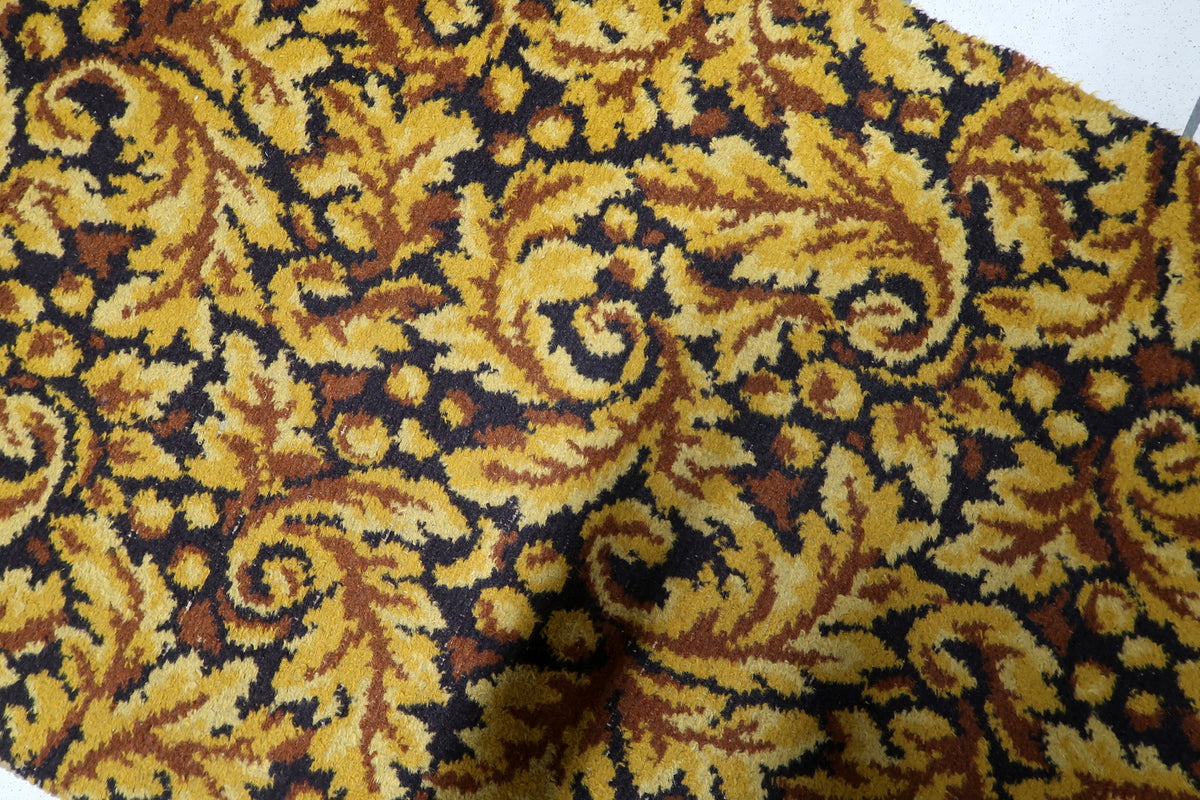 Soft durable synthetic acrylic pile surface on a 1960s vintage European rug with rich ochre and dark brown floral scrolls.