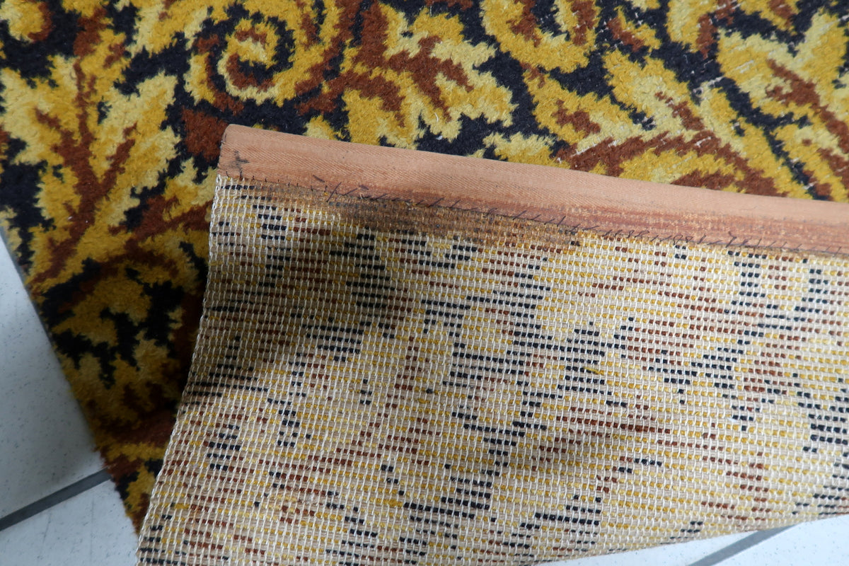 Warm gold and deep chocolate brown color palette on a mid-century German woven acrylic accent carpet.
