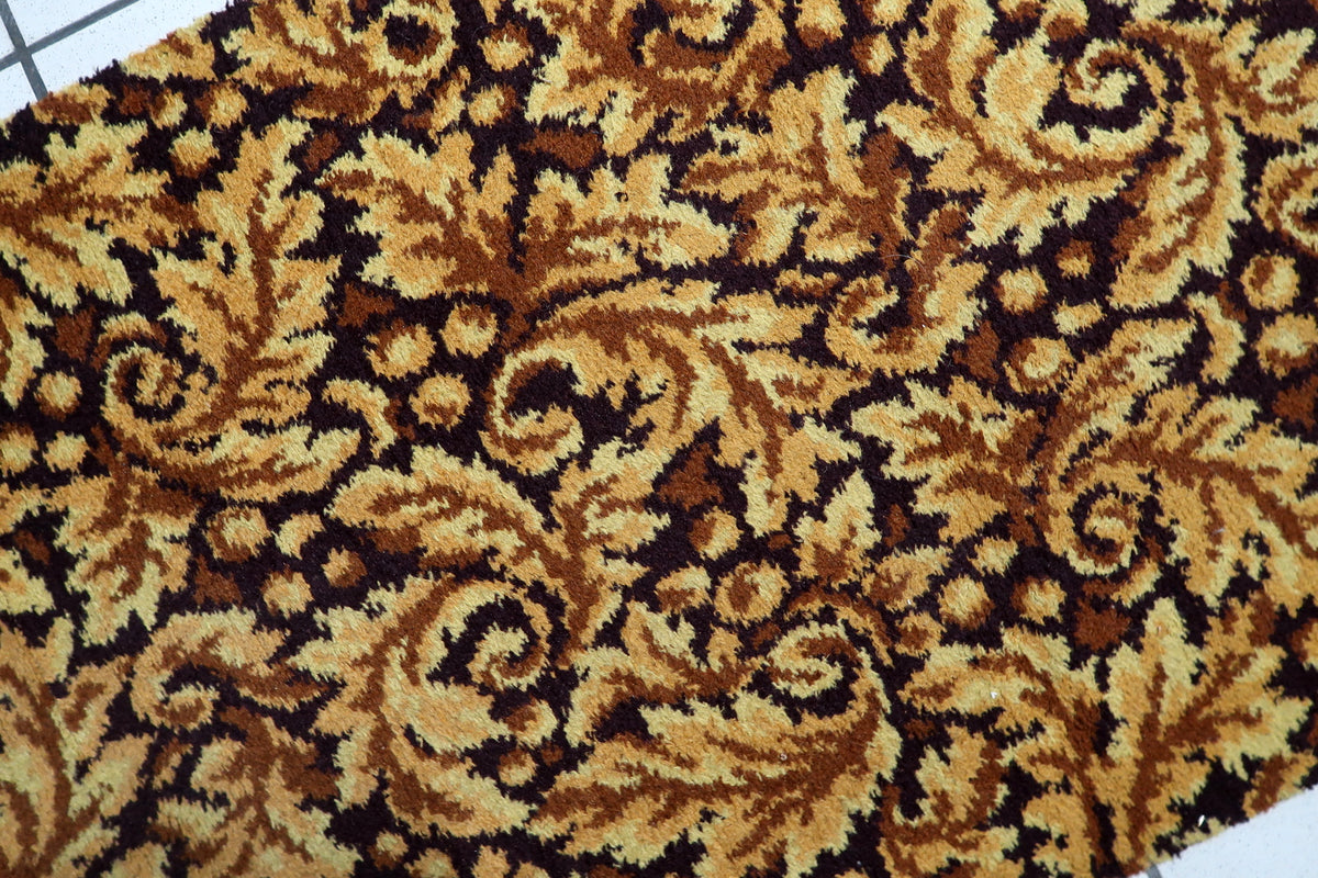 Decorative mid-century hallway rug featuring stylized leaves and floral scrollwork in autumnal tones