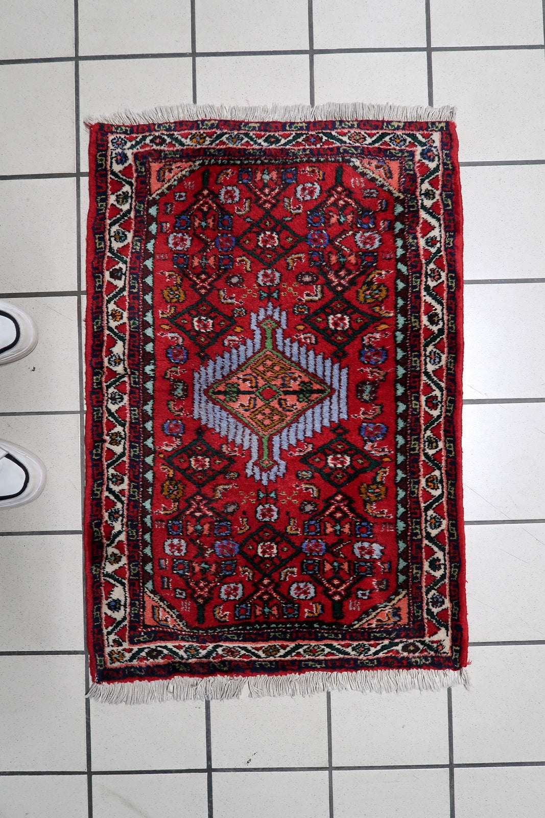 Decorative wool carpet with a classic medallion composition and warm red color palette