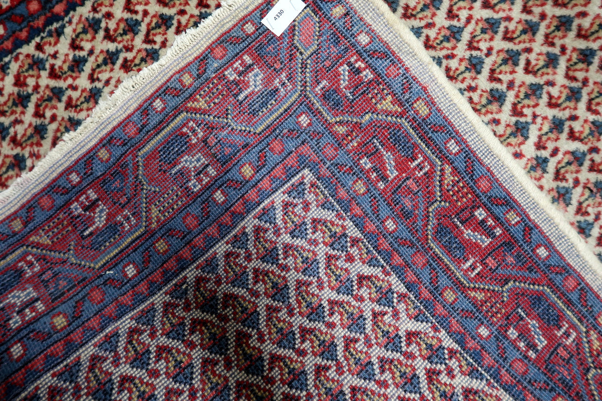 Elegant 1950s oriental floral pattern with deep red framing borders and light ivory interior field.