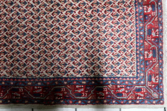 Mid-century hand-knotted Indian wool accent rug featuring classical floral motifs on an ivory field.