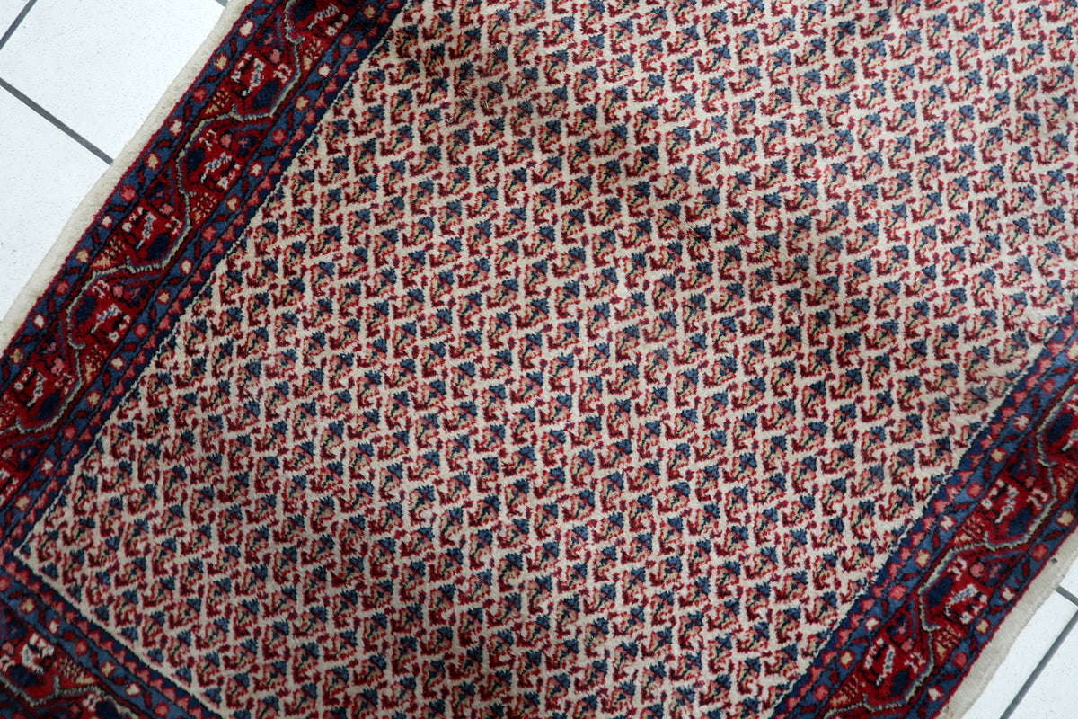 Intricate traditional floral motifs and ornamental leaf designs woven into a 3x5 ft Indian wool rug.