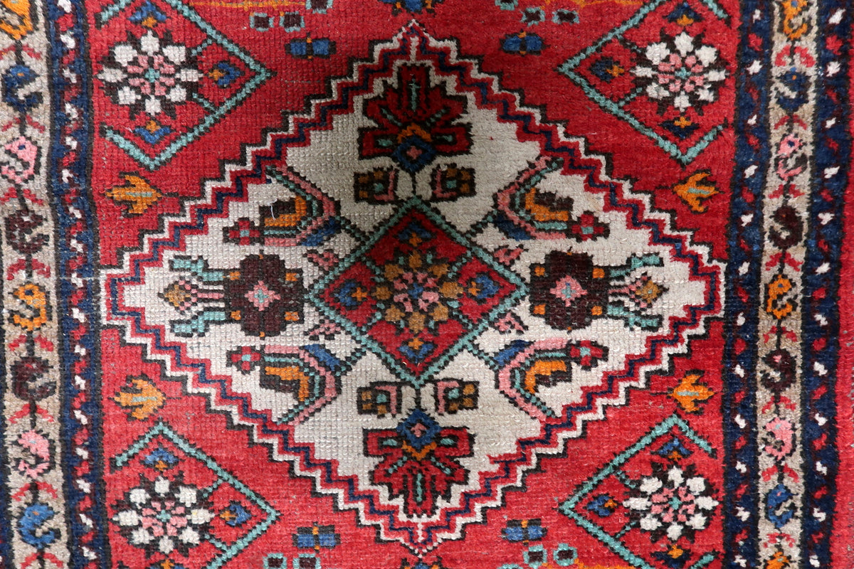 Intricate multi-band border design with repeating geometric rosettes and decorative guard bands.