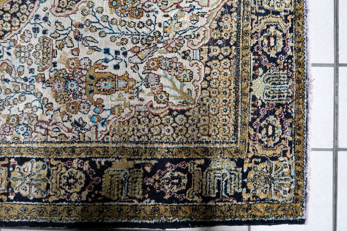 Fine hand-knotted Kashmir silk accent rug featuring a symmetrical central medallion on a lustrous ivory and ruby field.