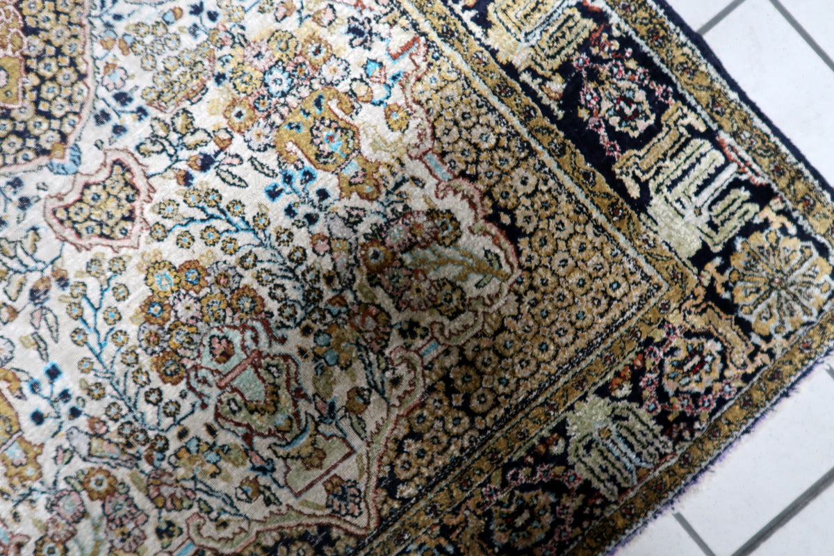 High knot density real silk pile carpet displaying natural directional sheen, silky luster, and intricate floral meanders.