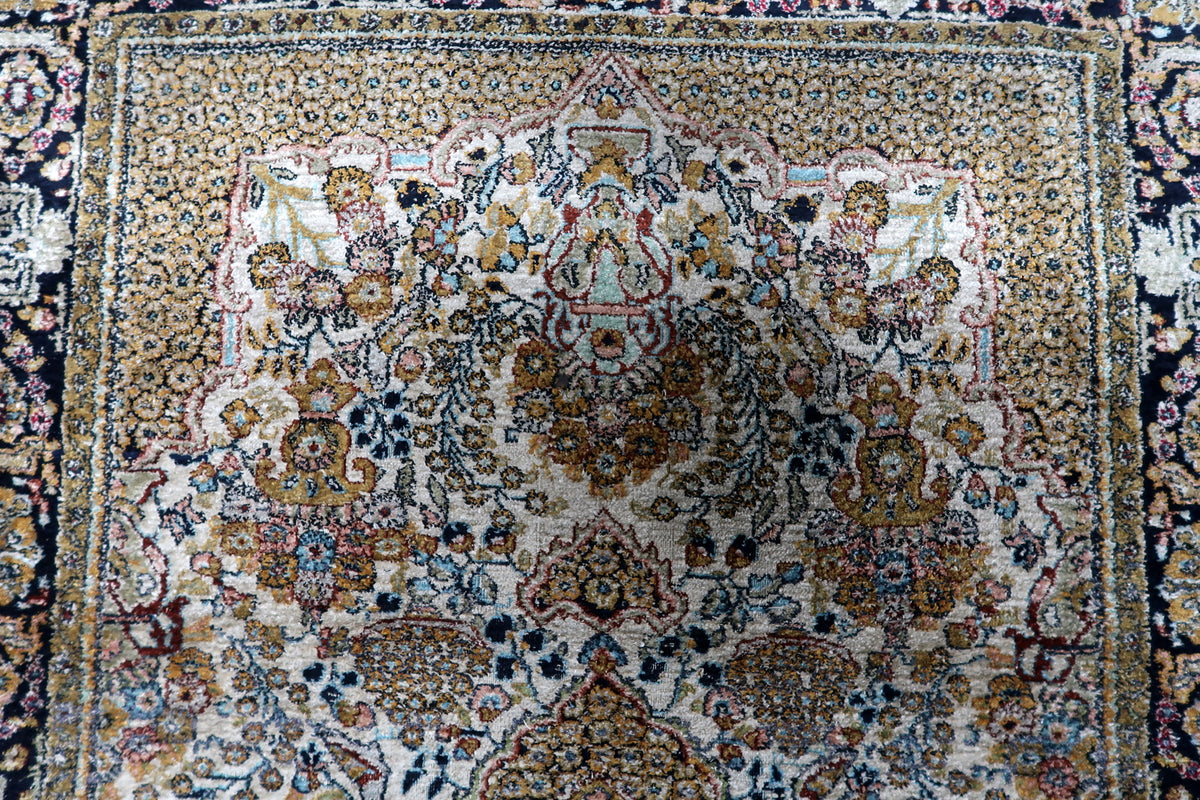 Classical floral spandrels and corner arabesques defining the interior field of a mid-century 1950s hand-knotted silk rug.