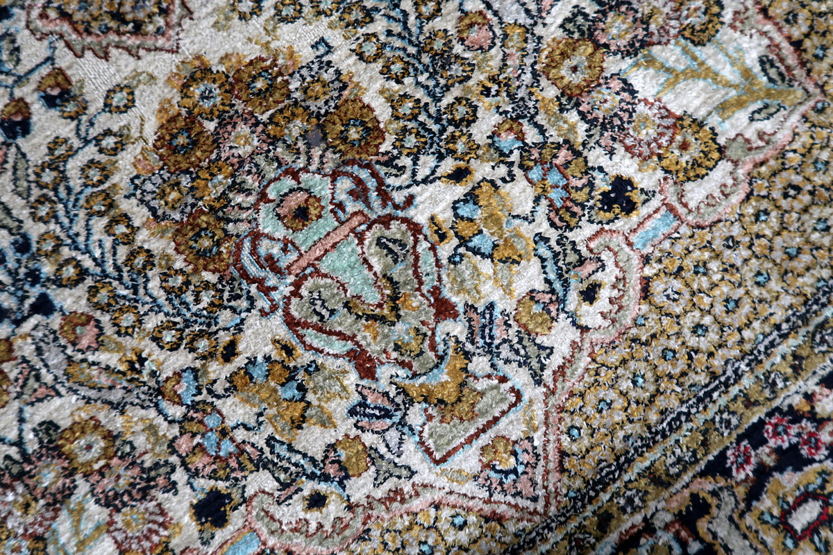 Soft pastel and rich jewel tone dyes including sapphire blue, ruby red, emerald, and cream ivory on a Kashmir silk rug.