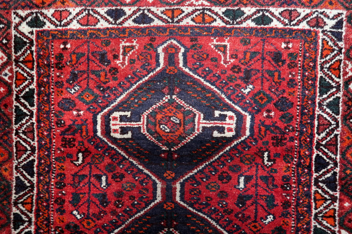 Authentic 1930s Persian wool rug with three symmetrical center medallions and traditional ornamental borders.