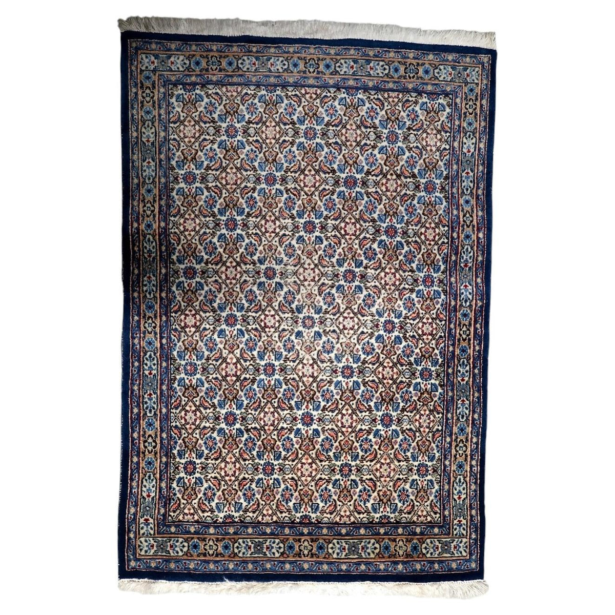 Vintage 1950s handmade wool area rug featuring classic floral palmettes in soft ivory and rich blue tones (Ref: 1C1295).